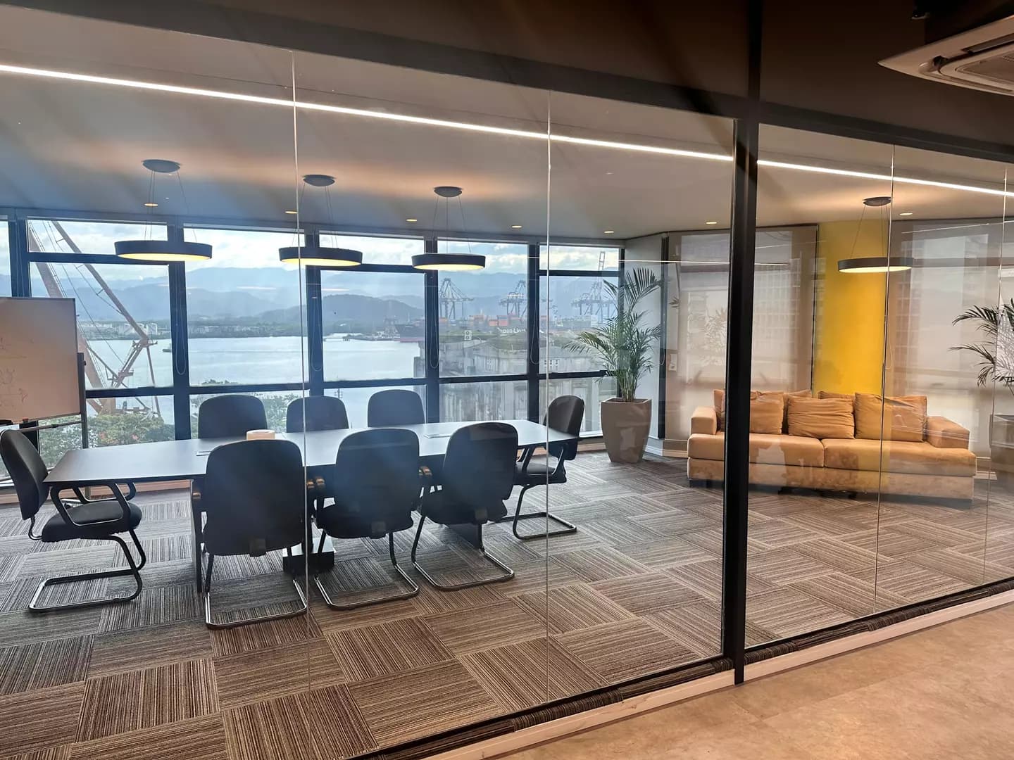 Sala de reunião envidraçada com vista para o porto de Santos